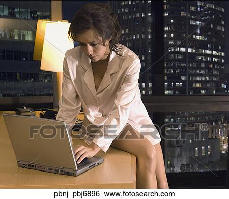 Stock Photograph - Hispanic woman using laptop in hotel room. Fotosearch