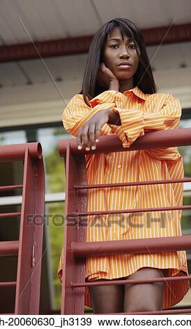 Low angle view of African woman standing on balcony View Large Photo Image Stock Photo - Low angle view of African woman standing on balcony. Fotosearch