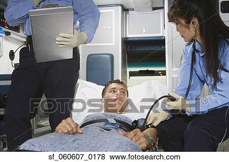 Stock Photo - Man in ambulance with paramedics. Fotosearch