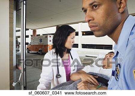 Stock Image - Man on gurney with paramedic and doctor. Fotosearch