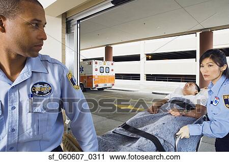 Stock Image - Man on gurney with paramedics. Fotosearch