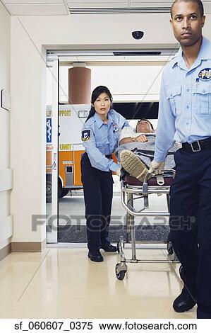 Stock Photography - Paramedics wheeling man into hospital on gurney. Fotosearch