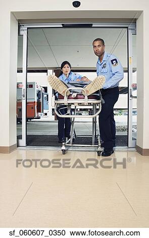 Paramedics wheeling person into hospital on gurney View Large Photo Image Stock Image - Paramedics wheeling person into hospital on gurney. Fotosearch