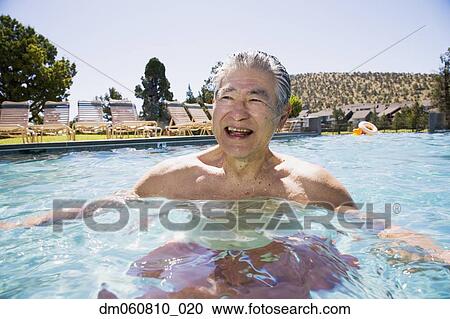 Stock Image - Senior Asian man smiling in swimming pool. Fotosearch