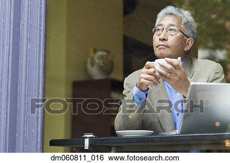 Senior Asian man with coffee and laptop at cafe View Large Photo Image Stock Photograph - Senior Asian man with coffee and laptop at cafe. Fotosearch
