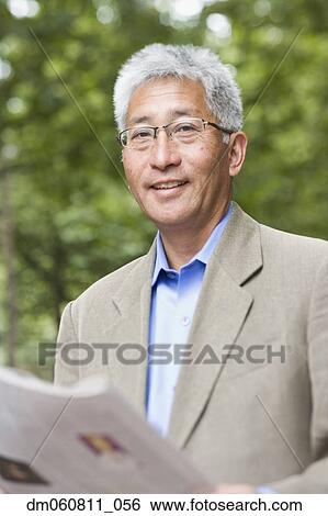 Senior Asian man with newspaper outdoors View Large Photo Image Stock Photograph - Senior Asian man with newspaper outdoors. Fotosearch