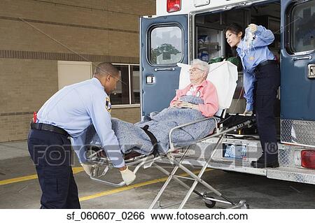 Stock Photograph - Senior woman being put in ambulance by paramedics. Fotosearch