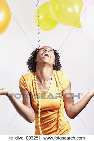 Studio shot of African woman laughing with balloons View Large Photo Image Stock Image - Studio shot of African woman laughing with balloons. Fotosearch