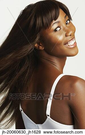 Stock Photo - Studio shot of African woman looking over shoulder. Fotosearch