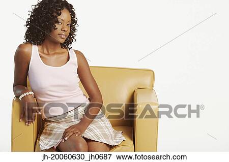 Studio shot of African woman sitting in armchair View Large Photo Image Stock Photo - Studio shot of African woman sitting in armchair. Fotosearch