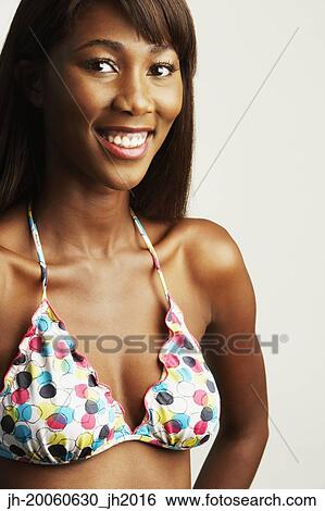 Stock Photograph - Studio shot of African woman smiling in bathing suit. Fotosearch