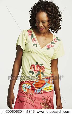 Studio shot of African woman smiling and looking down View Large Photo Image Stock Photograph - Studio shot of African woman smiling and looking down. Fotosearch