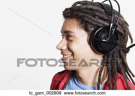 Stock Photo - Studio shot of young Hispanic man wearing headphones. Fotosearch
