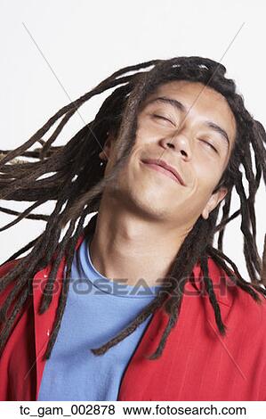 Studio shot of young Hispanic man swinging deadlocks with eyes closed View Large Photo Image Stock Photo - Studio shot of young Hispanic man swinging deadlocks with eyes closed. Fotosearch
