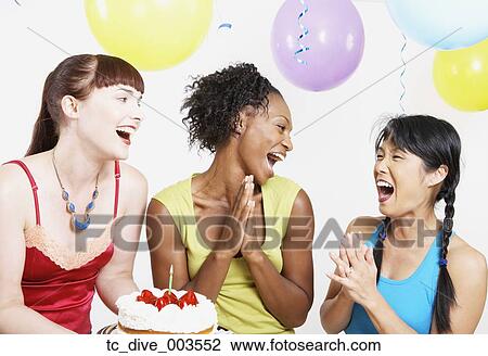 Three women laughing with cake and lit candle and balloons View Large Photo Image Stock Image - Three women laughing with cake and lit candle and balloons. Fotosearch