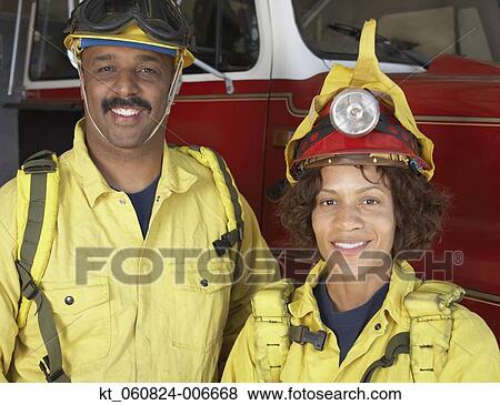 Two African firefighters next to fire truck View Large Photo Image Stock Photo - Two African firefighters next to fire truck. Fotosearch