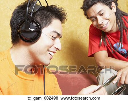 Stock Photo - Two young men looking at cds indoors. Fotosearch