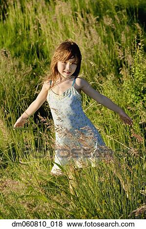 Young Asian girl with arms out in tall grass View Large Photo Image Stock Photo - Young Asian girl with arms out in tall grass. Fotosearch