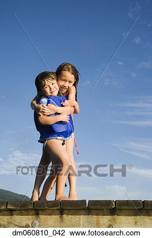 Young Asian sisters hugging on dock View Large Photo Image Stock Image - Young Asian sisters hugging on dock. Fotosearch