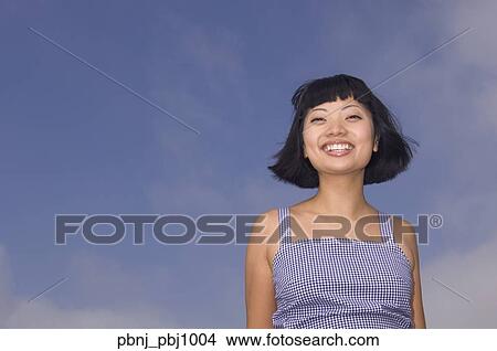 Picture - Young Asian woman smiling outdoors. Fotosearch