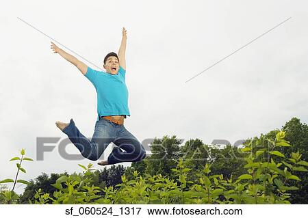 Young man jumping outdoors View Large Photo Image Stock Photo - Young man jumping outdoors. Fotosearch