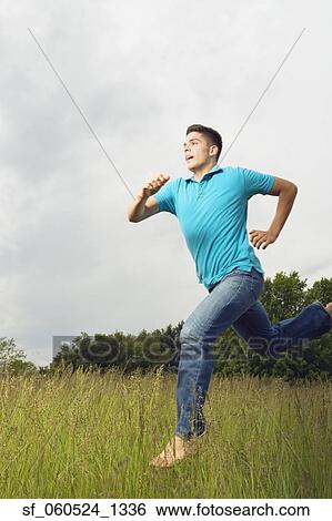 Stock Photograph - Young man running barefoot outdoors. Fotosearch