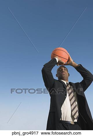 African businessman shooting basketball View Large Photo Image Stock Photo - African businessman shooting basketball. Fotosearch