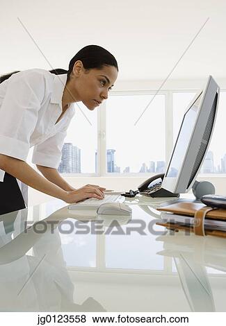 African businesswoman looking at computer View Large Photo Image Stock Photo - African businesswoman looking at computer. Fotosearch