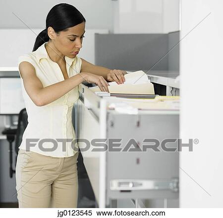 African businesswoman looking in file cabinet View Large Photo Image Stock Photography - African businesswoman looking in file cabinet. Fotosearch