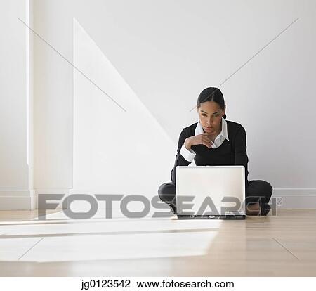 African businesswoman on floor looking at laptop View Large Photo Image Stock Image - African businesswoman on floor looking at laptop. Fotosearch
