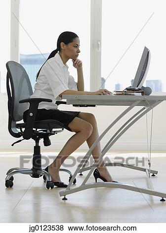 Stock Photo - African businesswoman working at desk. Fotosearch