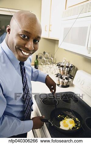 African man cooking eggs in kitchen View Large Photo Image Stock Photograph - African man cooking eggs in kitchen. Fotosearch