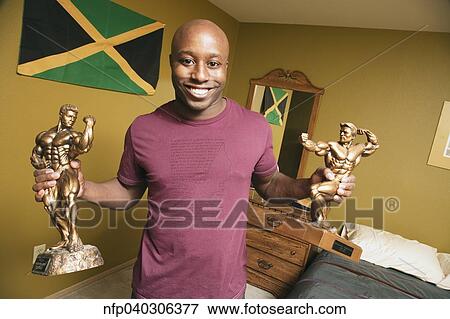 African man holding body building trophies View Large Photo Image Stock Photo - African man holding body building trophies. Fotosearch