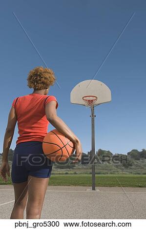 African woman holding basketball on court View Large Photo Image Stock Image - African woman holding basketball on court. Fotosearch