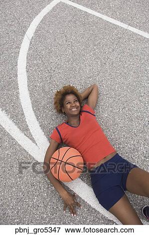 African woman laying on basketball court View Large Photo Image Stock Photo - African woman laying on basketball court . Fotosearch
