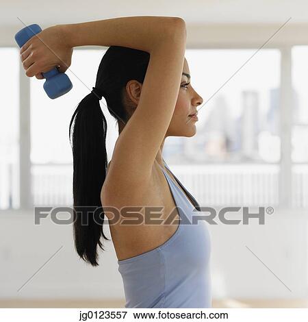 Stock Photo - African woman lifting dumbbell. Fotosearch