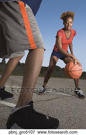 Stock Photo - African woman playing basketball. Fotosearch