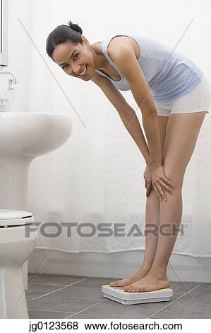 African woman standing on bathroom scale View Large Photo Image Stock Photo - African woman standing on bathroom scale. Fotosearch