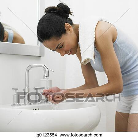 African woman washing face in bathroom sink View Large Photo Image Picture - African woman washing face in bathroom sink. Fotosearch