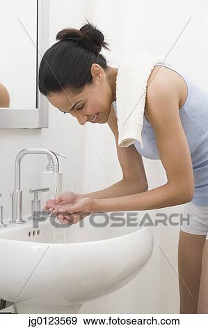 African woman washing face in bathroom sink View Large Photo Image Stock Photo - African woman washing face in bathroom sink. Fotosearch