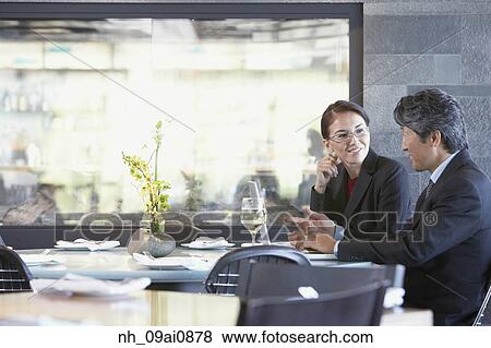 Asian businessman and businesswoman talking at restaurant View Large Photo Image Stock Photo - Asian businessman and businesswoman talking at restaurant. Fotosearch