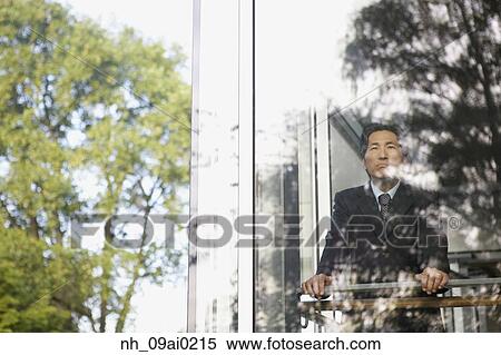 Asian businessman looking through window View Large Photo Image Stock Photography - Asian businessman looking through window. Fotosearch