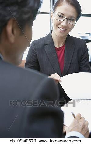 Asian businesswoman discussing paperwork with coworker View Large Photo Image Stock Photo - Asian businesswoman discussing paperwork with coworker. Fotosearch