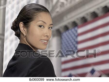 Asian businesswoman in front of American flag View Large Photo Image Stock Photo - Asian businesswoman in front of American flag. Fotosearch