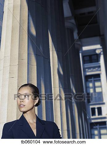 Picture - Asian businesswoman standing next to columns. Fotosearch