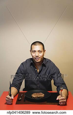 Asian man at dinner table with steak View Large Photo Image Stock Photo - Asian man at dinner table with steak. Fotosearch