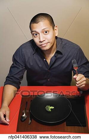 Asian man with one piece of broccoli on plate View Large Photo Image Stock Photo - Asian man with one piece of broccoli on plate. Fotosearch