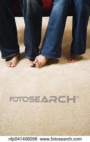Couple playing footsie on carpet View Large Photo Image Stock Photograph - Couple playing footsie on carpet. Fotosearch