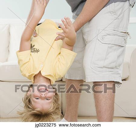 Stock Photography - Father holding young son upside down. Fotosearch
