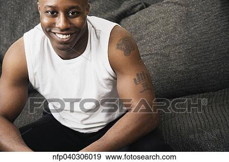 Stock Photo - High angle view of African man on sofa. Fotosearch
